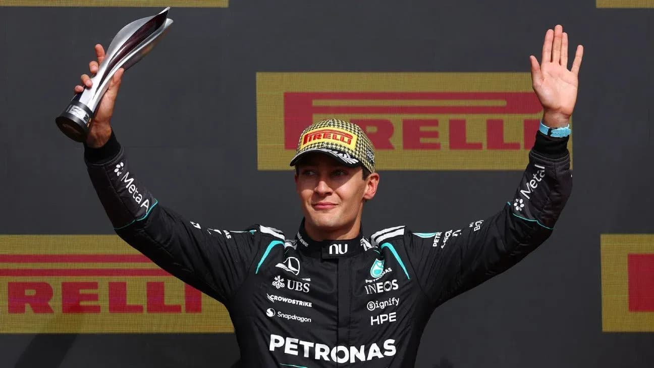 Driver celebrating with trophy on podium