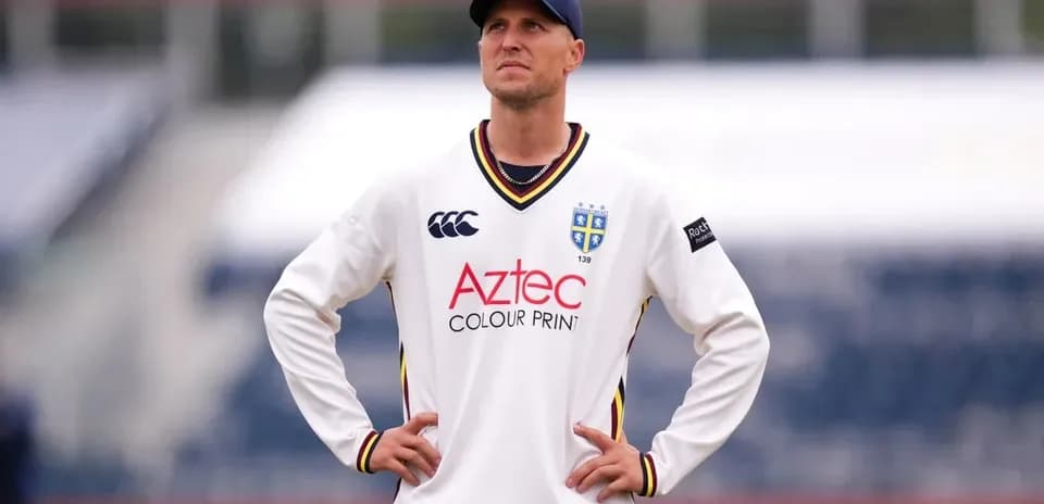 Cricketer in white kit observing the field