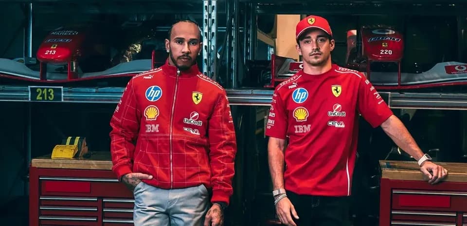 Two drivers in Ferrari team apparel posing in garage