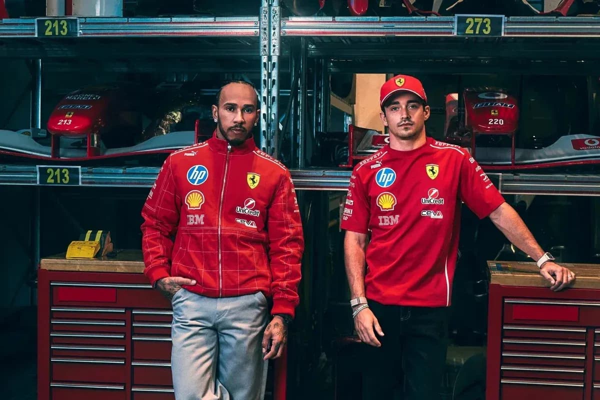 Two drivers in Ferrari team apparel posing in garage