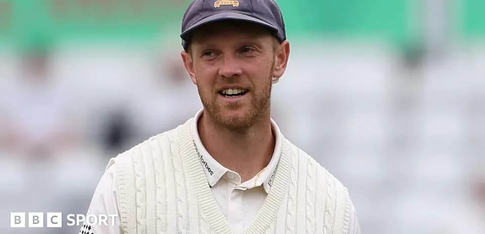 Cricketer in white sweater during match