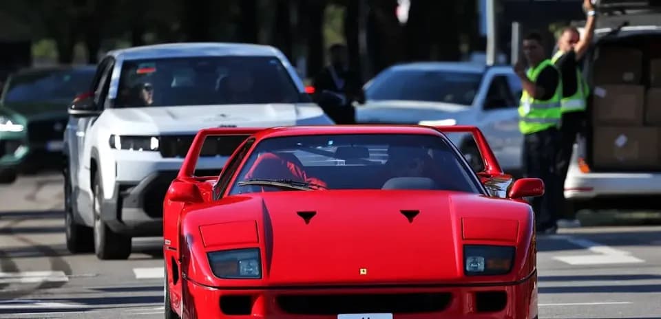 Red sports car driving in busy street