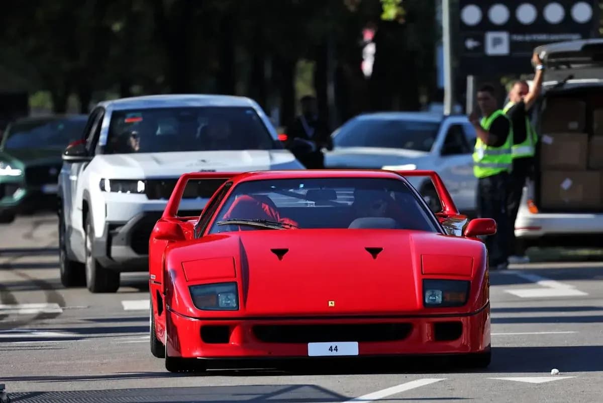 Red sports car driving in busy street