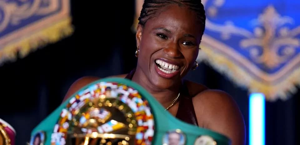 Boxer proudly displaying championship belts at event