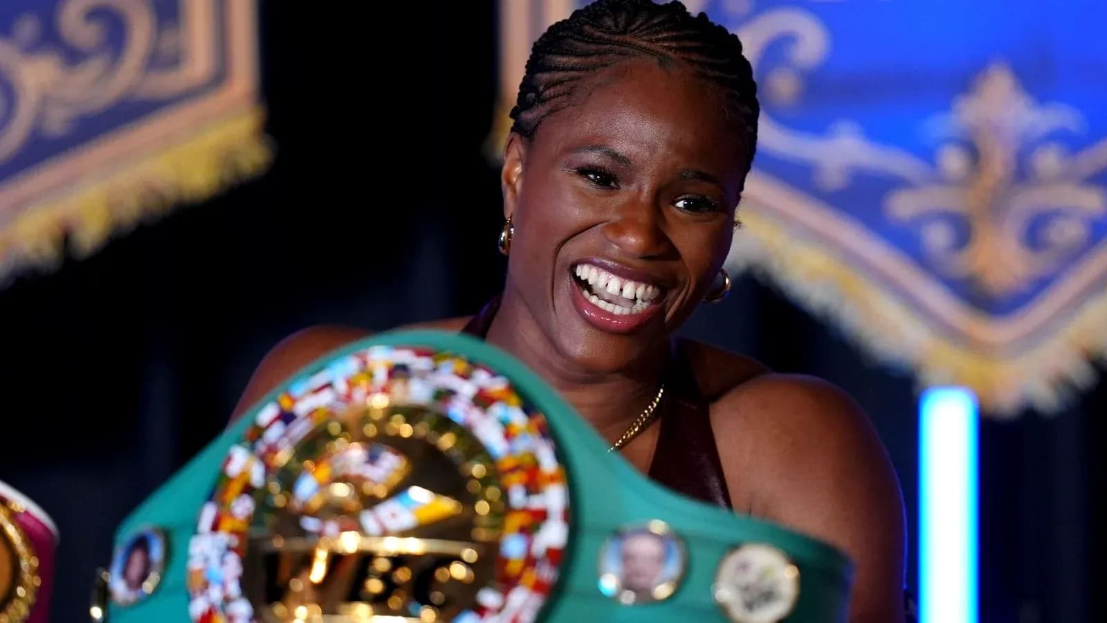 Boxer proudly displaying championship belts at event