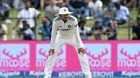 Cricketer in white uniform fielding on the pitch