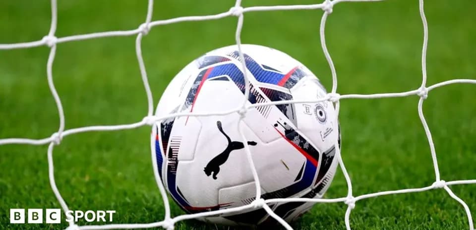 Soccer ball resting in goal net on field