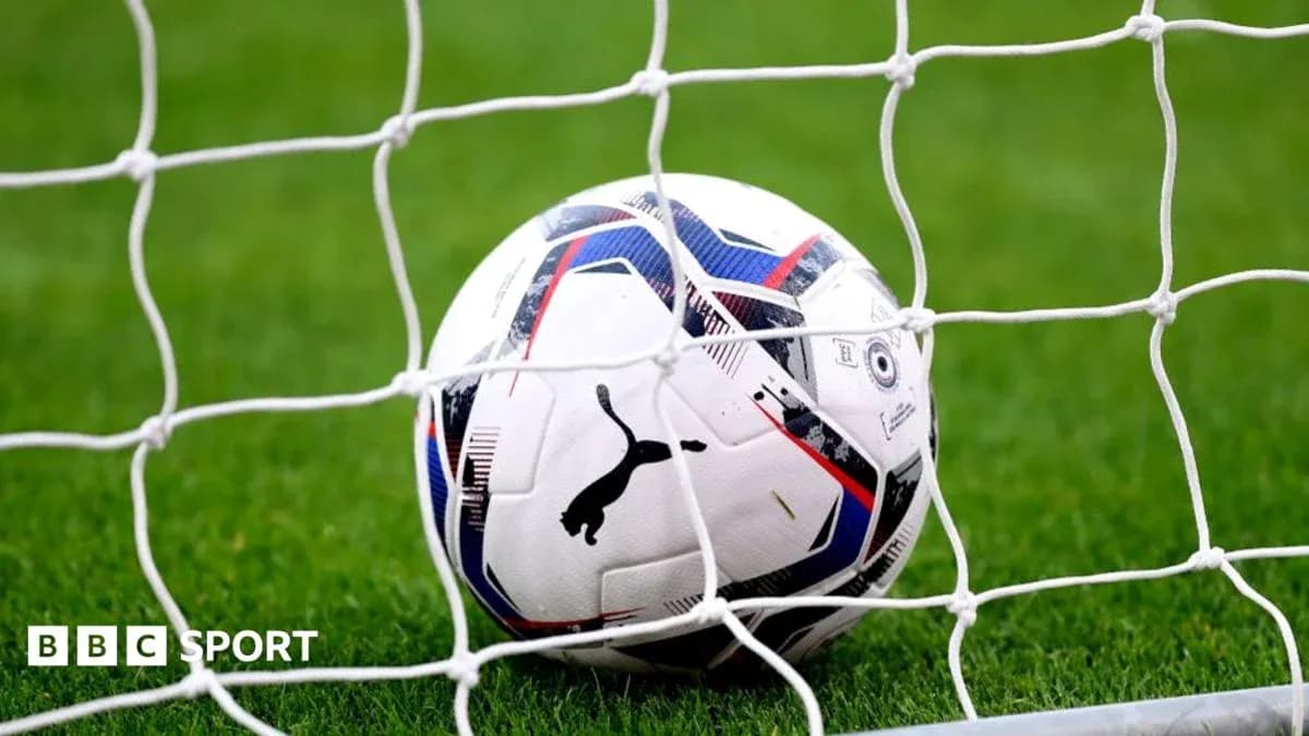 Soccer ball resting in goal net on field