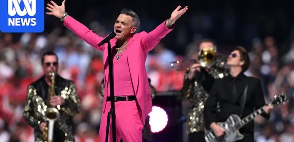 Singer performing in pink outfit with band