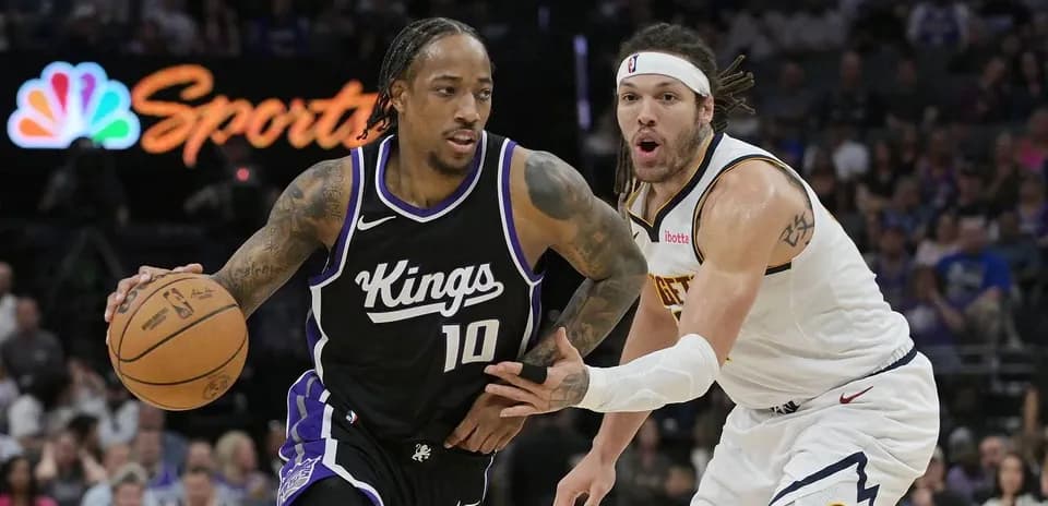 Player dribbling basketball with defender closely behind