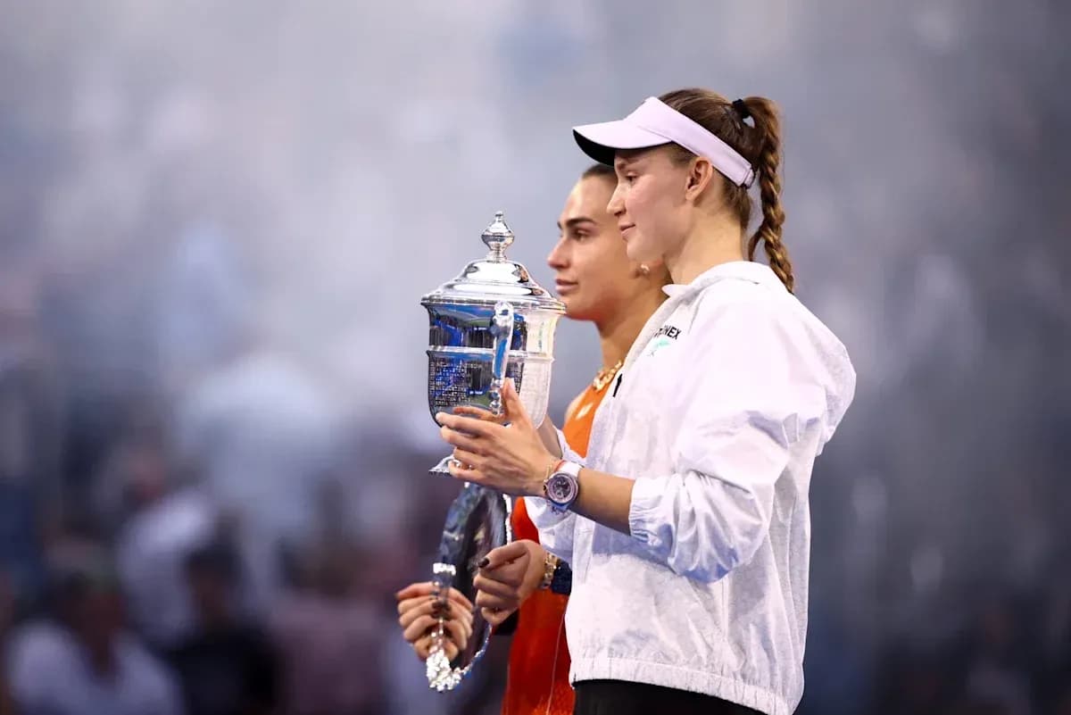 Two tennis players holding trophies during ceremony