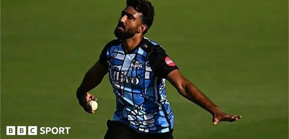 Cricketer bowling with ball during match