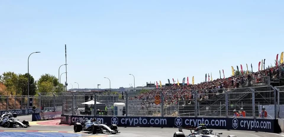 Two Formula 1 cars racing at a circuit