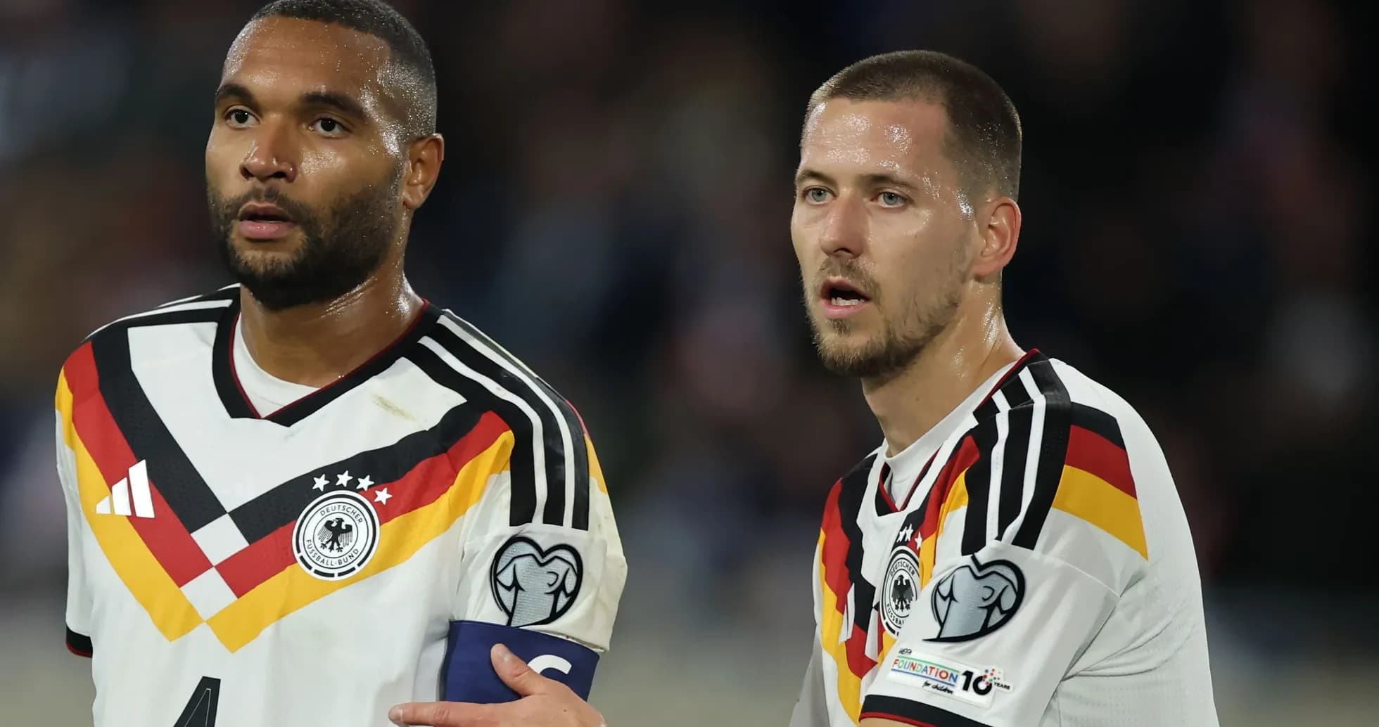 Two German players discussing on the field