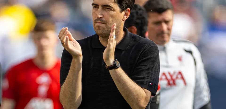 Coach applauding during match with players in background