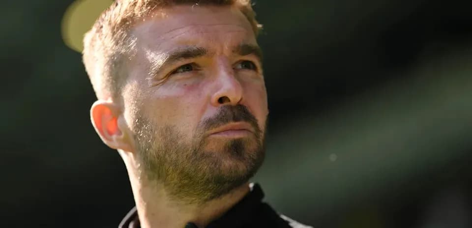Man with short hair looking thoughtfully into distance