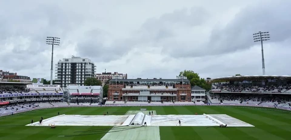 Ground staff covering pitch with tarp at Lord's