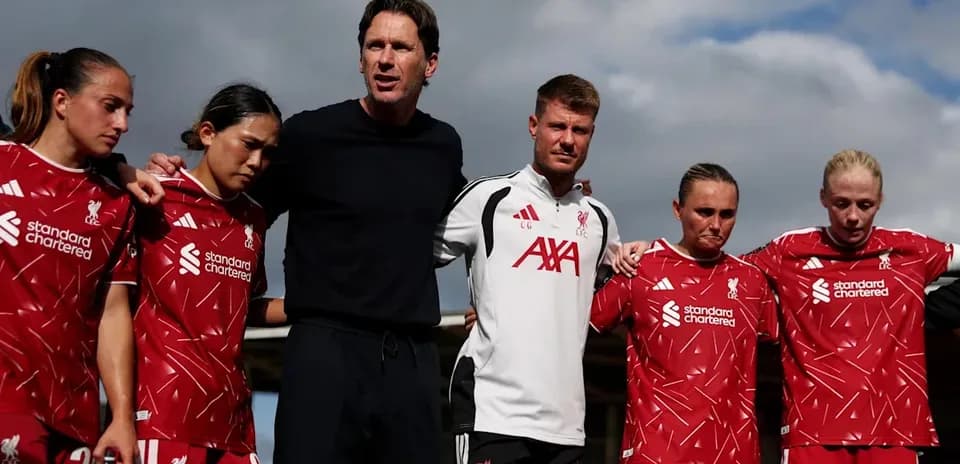Liverpool women's team in a huddle with coaches