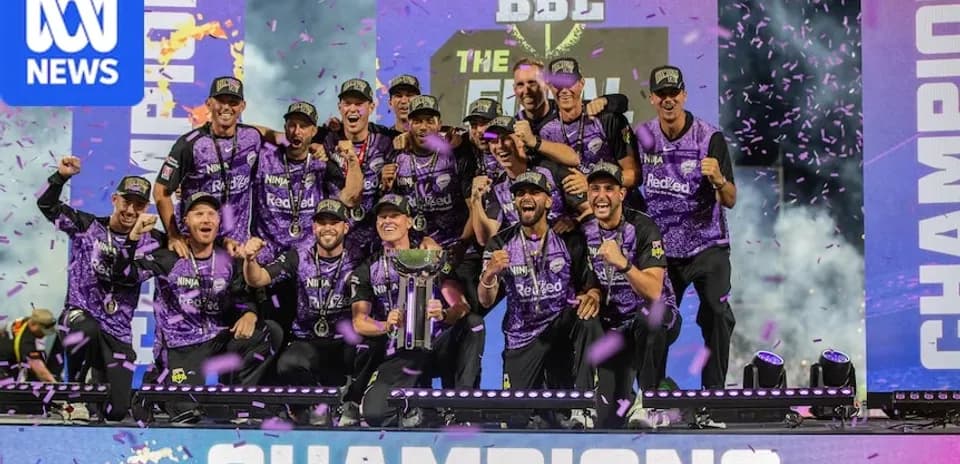 Cricket team celebrating championship victory on stage