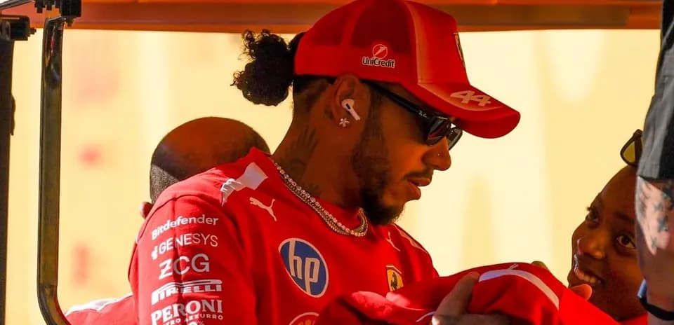 Driver wearing Ferrari gear interacting with supporters