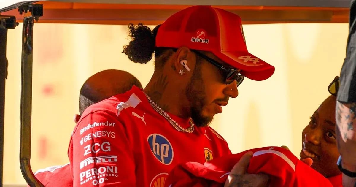 Driver wearing Ferrari gear interacting with supporters