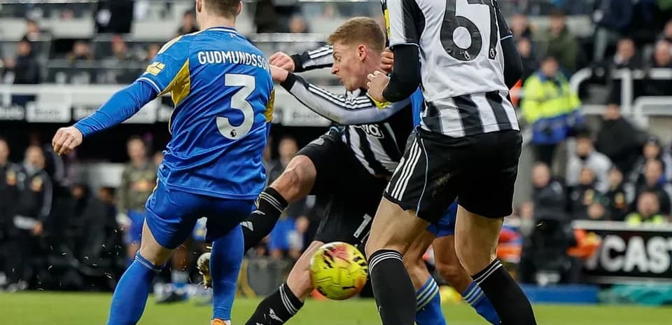 Leeds player tackling Newcastle opponent during match