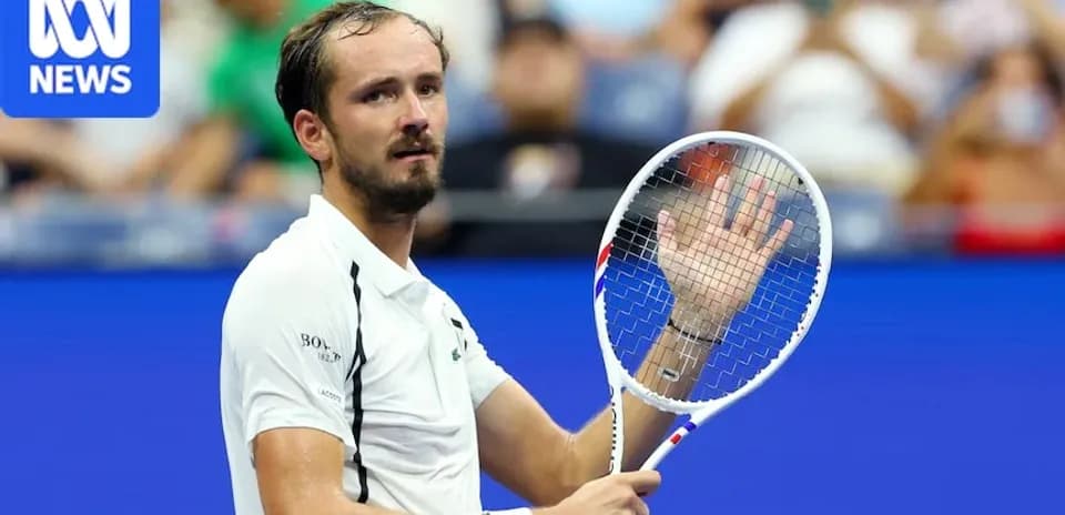 Tennis player waving with racket during match