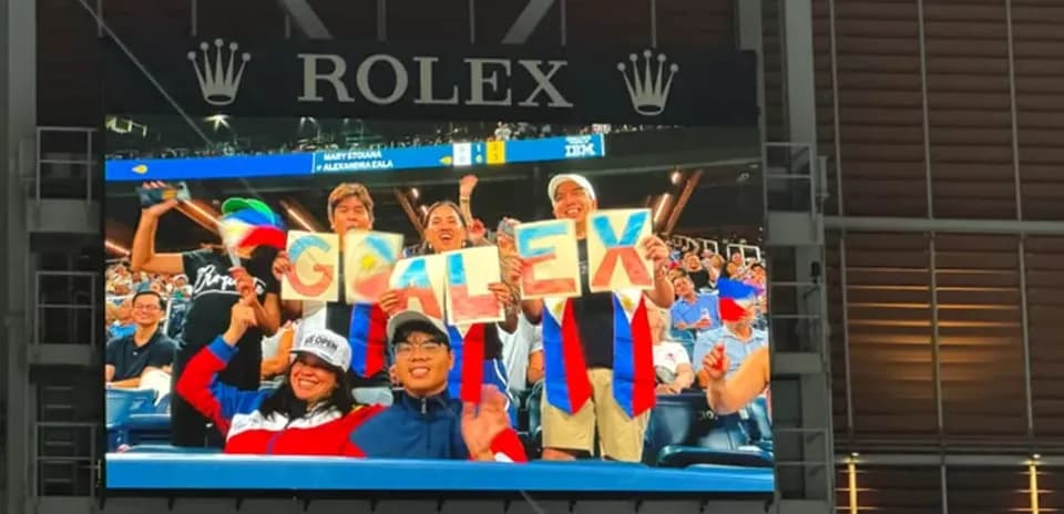 Fans holding a sign that says 'GO ALEX' in stadium