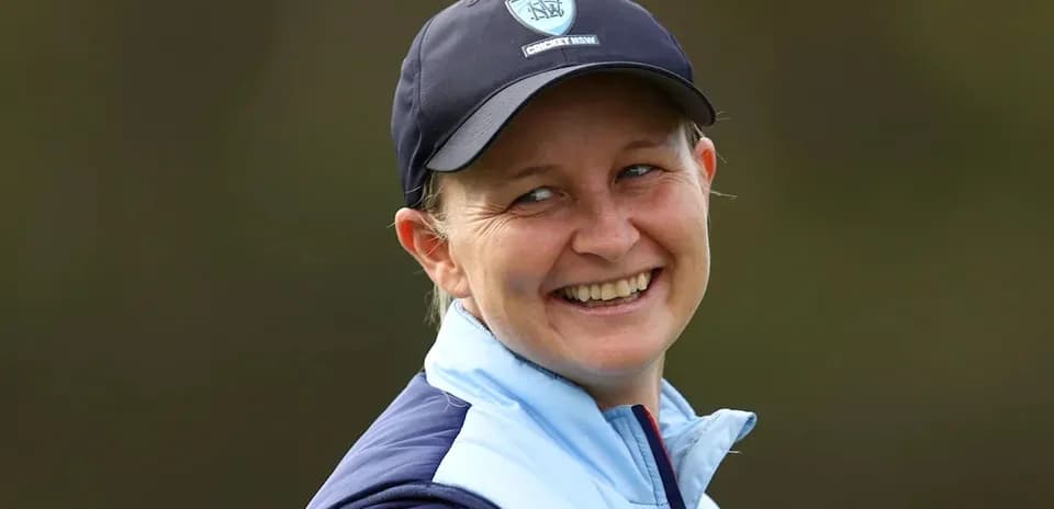 Cricket player smiling during outdoor event