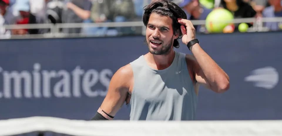 Tennis player adjusting hair during a match