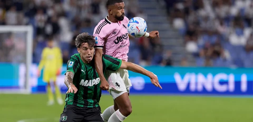 Player from Juventus challenging Sassuolo player for the ball