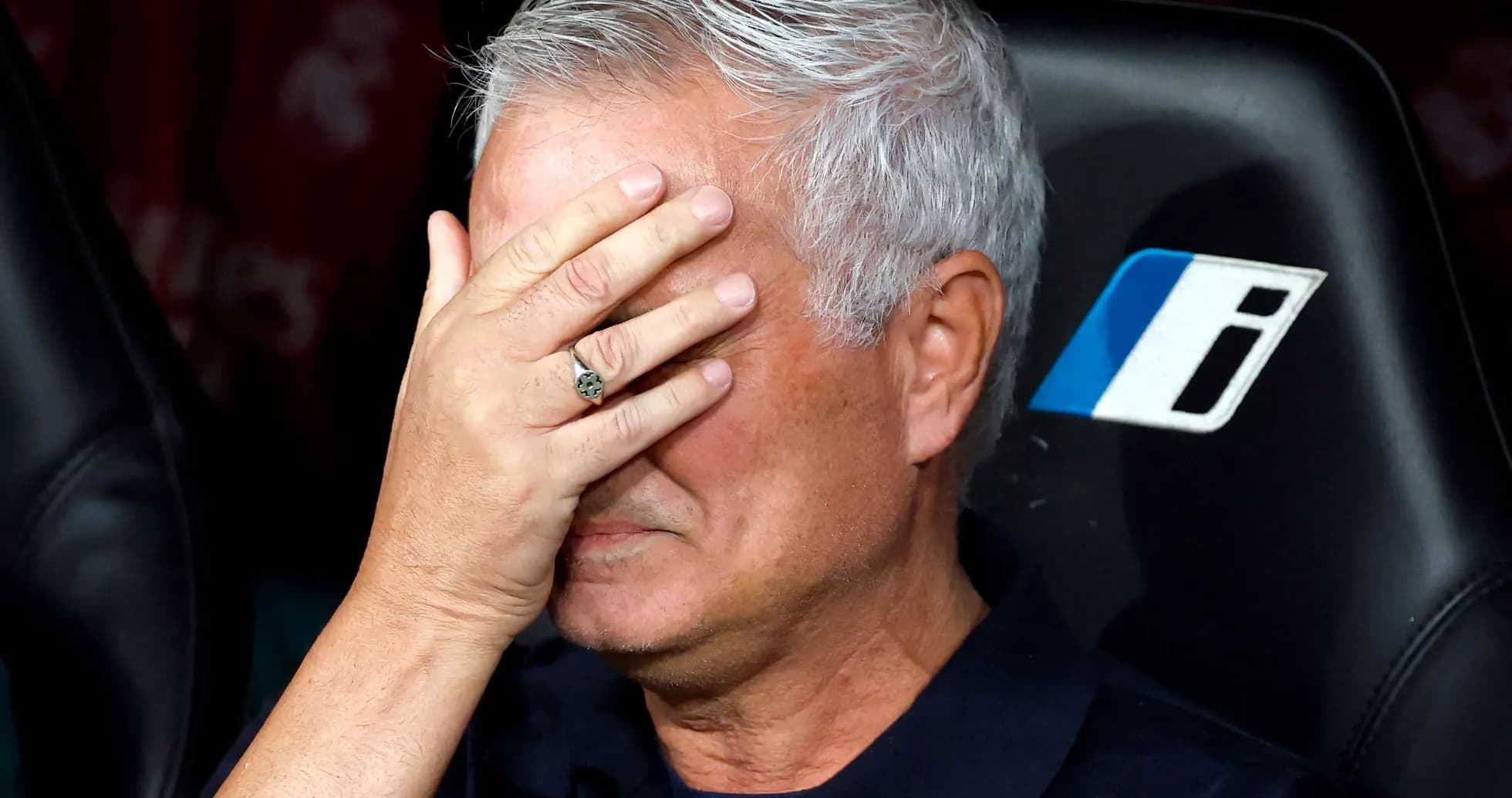 Coach with hand on face during match