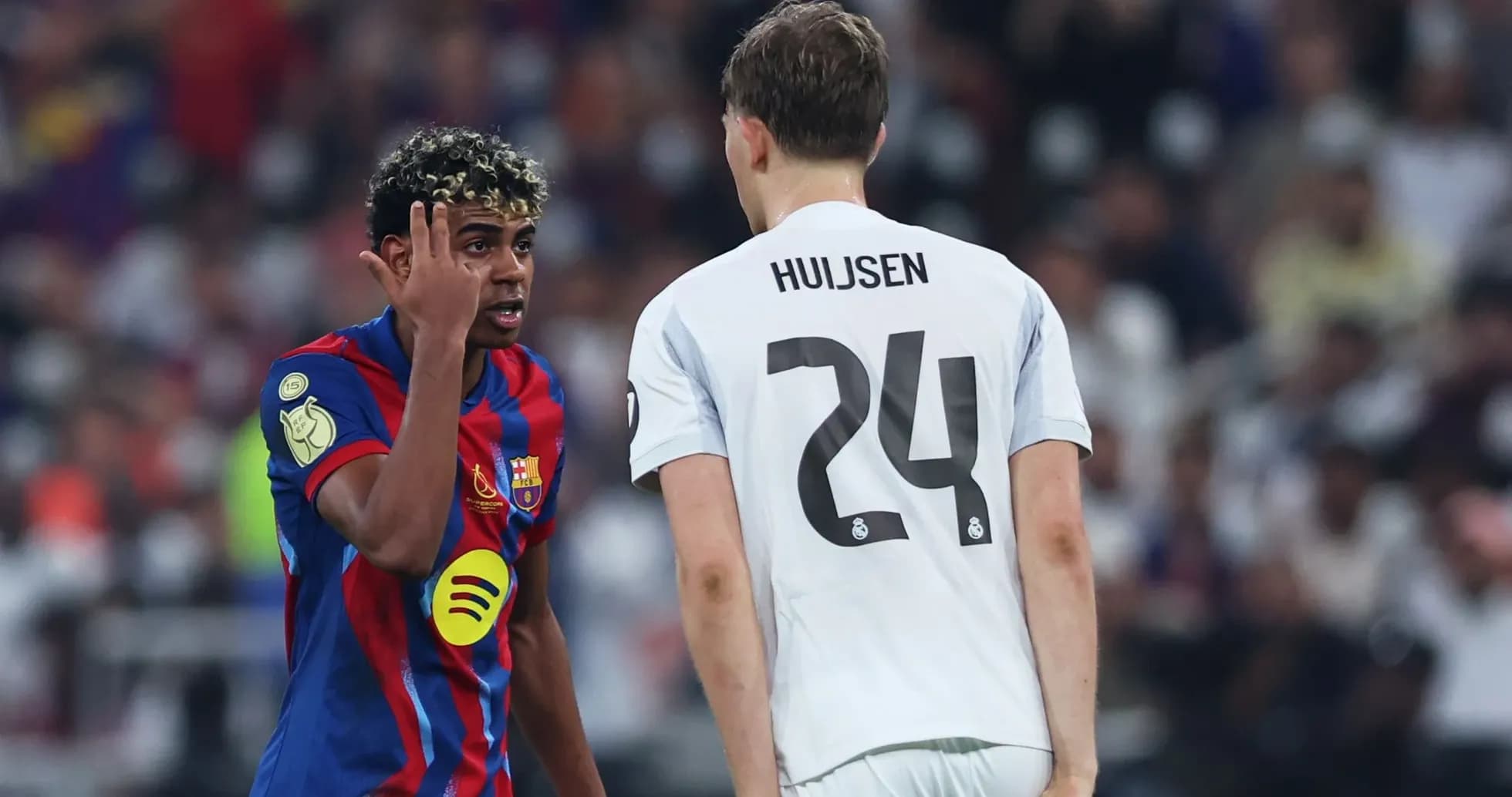 Barcelona player gesturing towards Real Madrid opponent