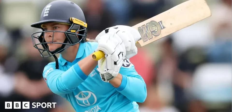 Cricketer batting during a match in blue uniform