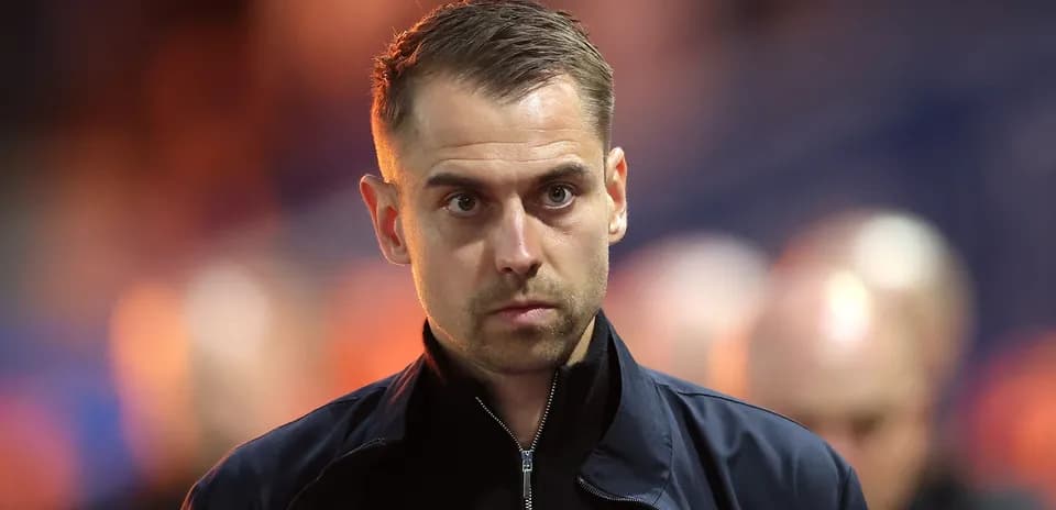 Person in dark jacket walking in stadium