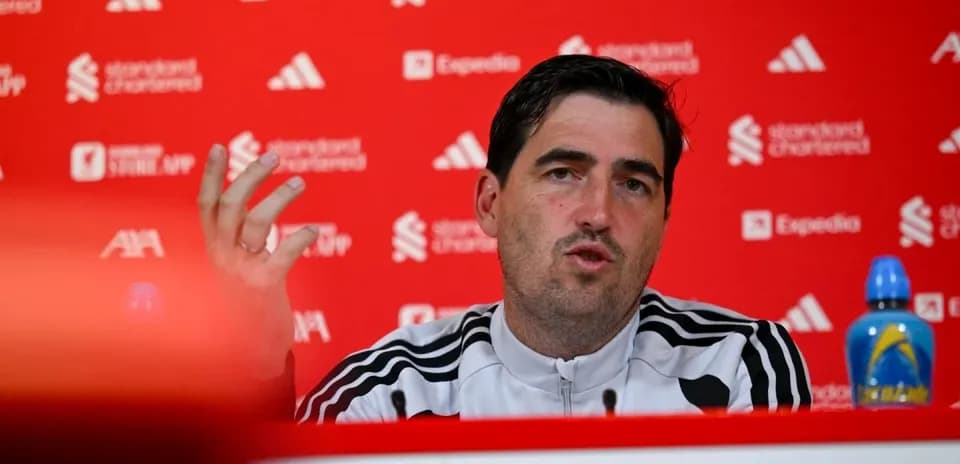 Manager speaking at press conference with sponsors' backdrop