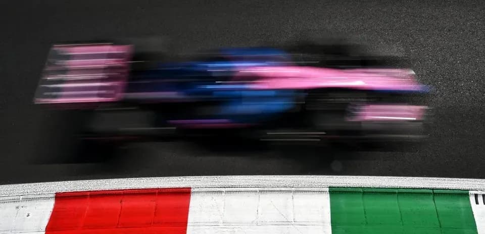 Formula 1 car racing past track curbing