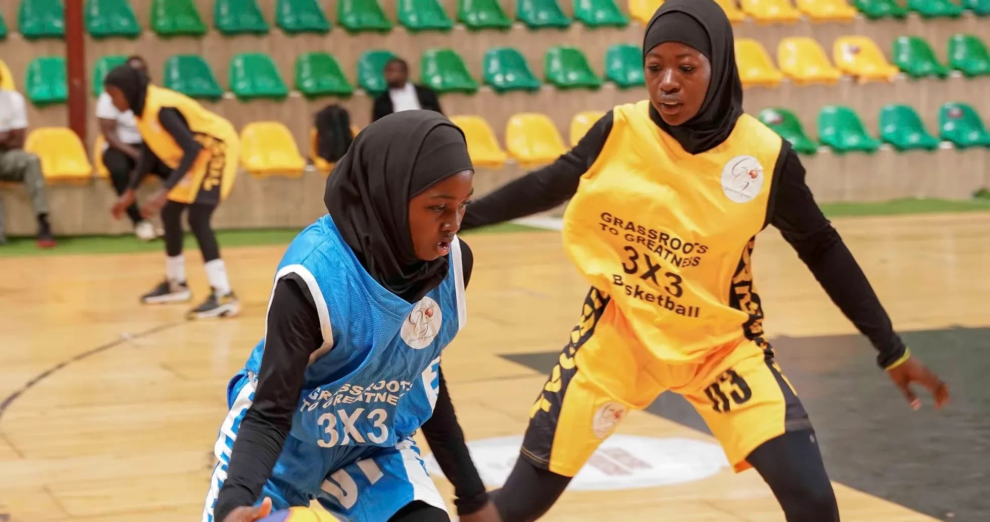 Two players dribbling basketball during a match