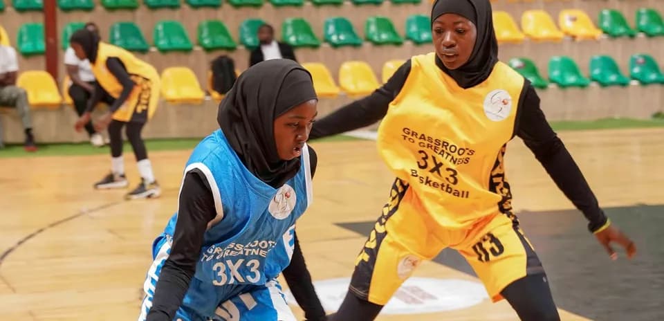 Two players dribbling basketball during a match