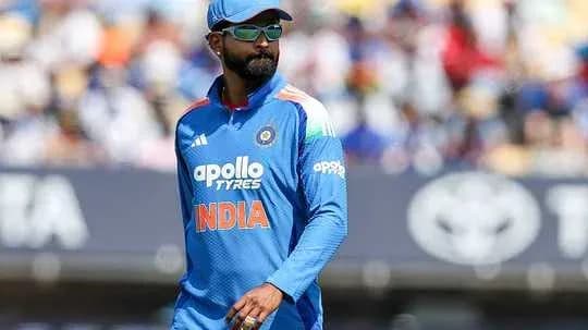 Cricketer in blue India uniform walking on field
