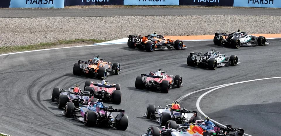 Multiple Formula 1 cars racing around a bend