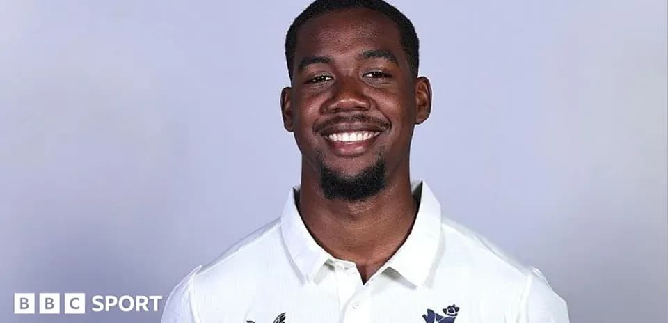Smiling cricketer in white team shirt portrait