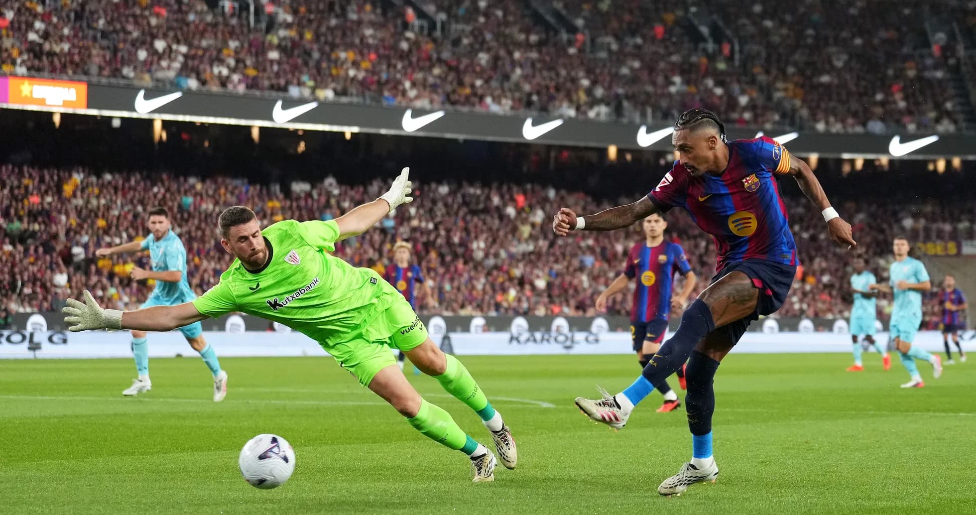 Player shooting at goal while goalkeeper dives