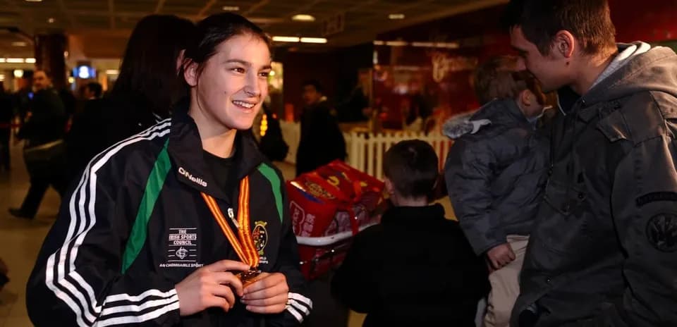 Athlete smiling with medal in airport setting