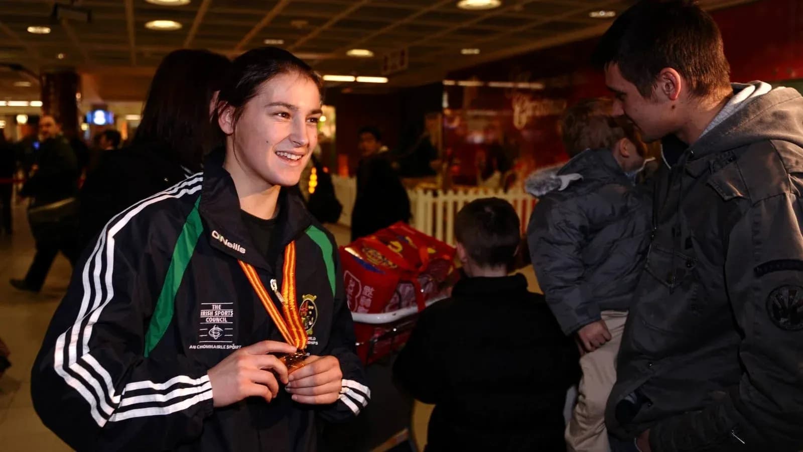 Athlete smiling with medal in airport setting