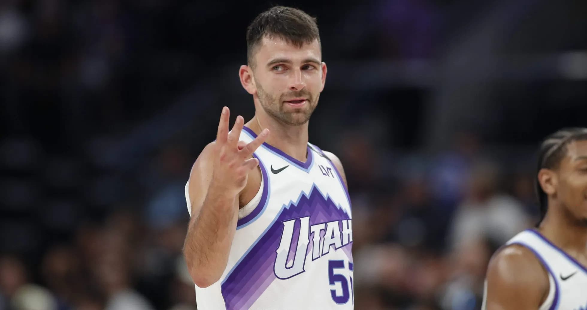 Player signaling three points during basketball game