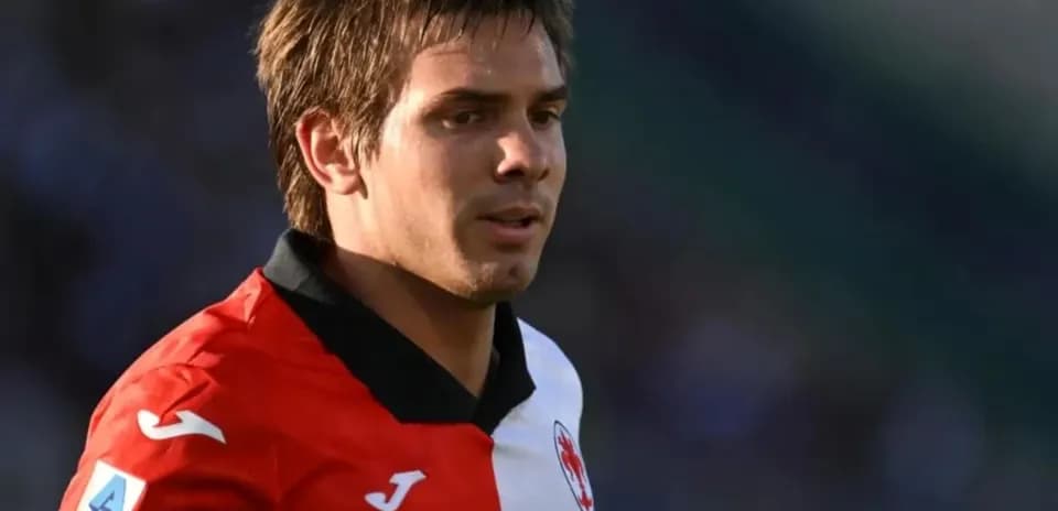Player wearing red and white jersey on field