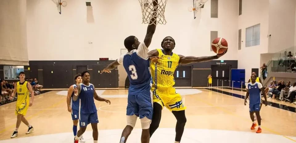 Player dunking while being defended during basketball game