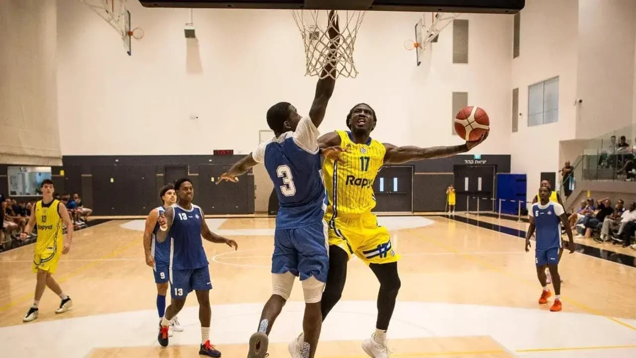 Player dunking while being defended during basketball game