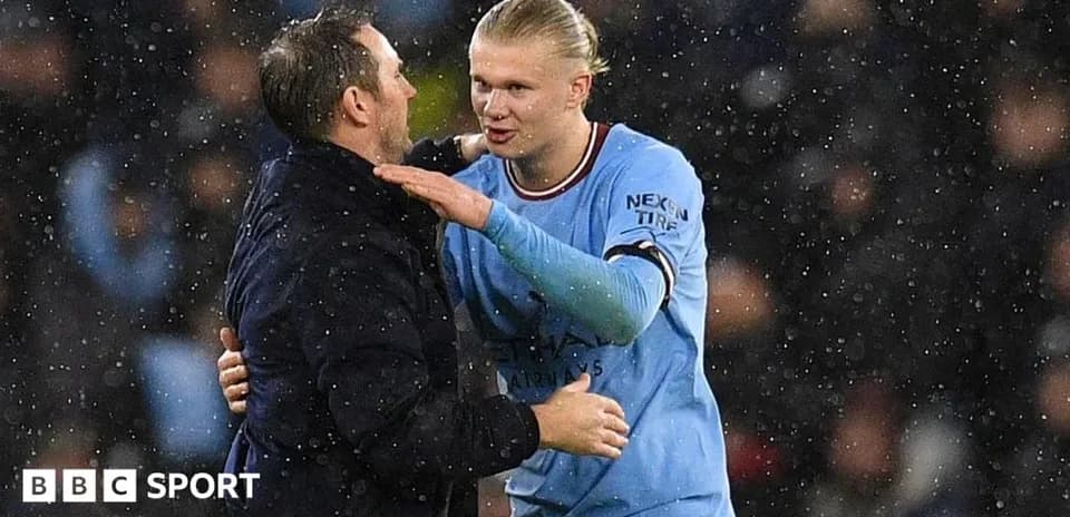Player and coach discussing on rainy pitch